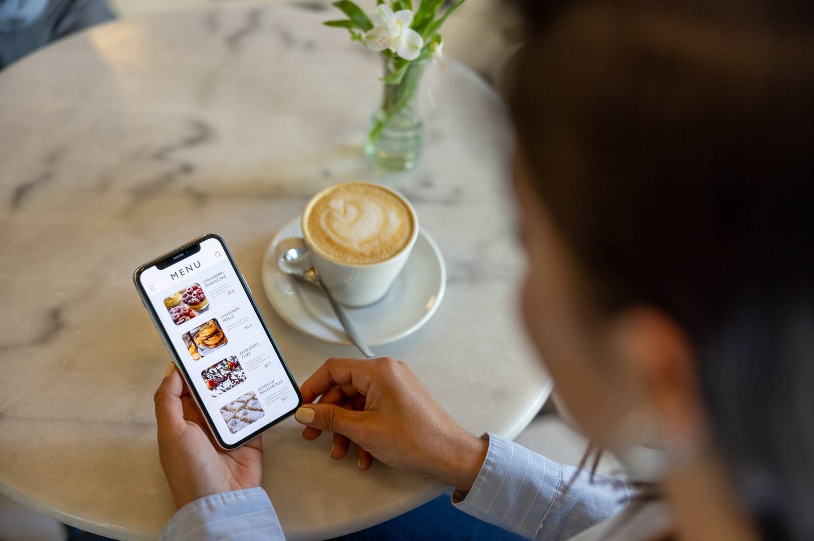 Persona che guarda il menu del ristorante nel telefono